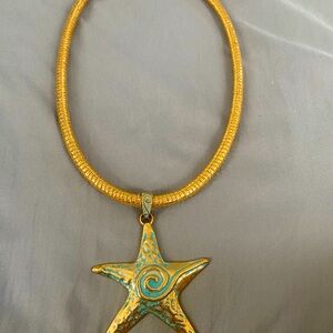 Blue tone stat fish pendant on 20in gold leather  cord. Magnetic closur